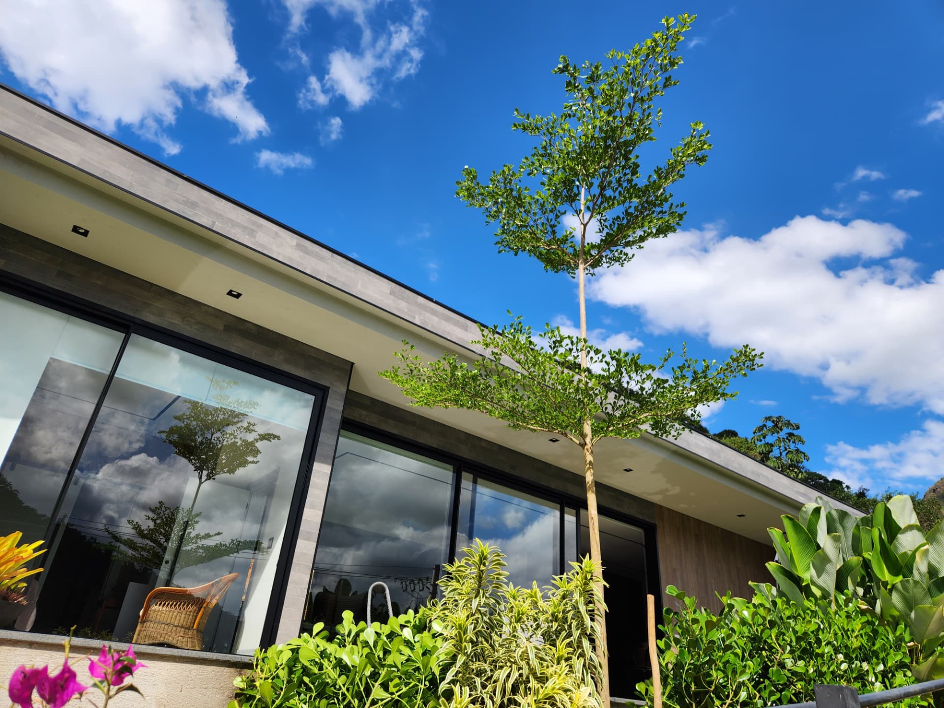 Casa em Itaipava com paisagismo real da Império Plantas e céu azul da Serra